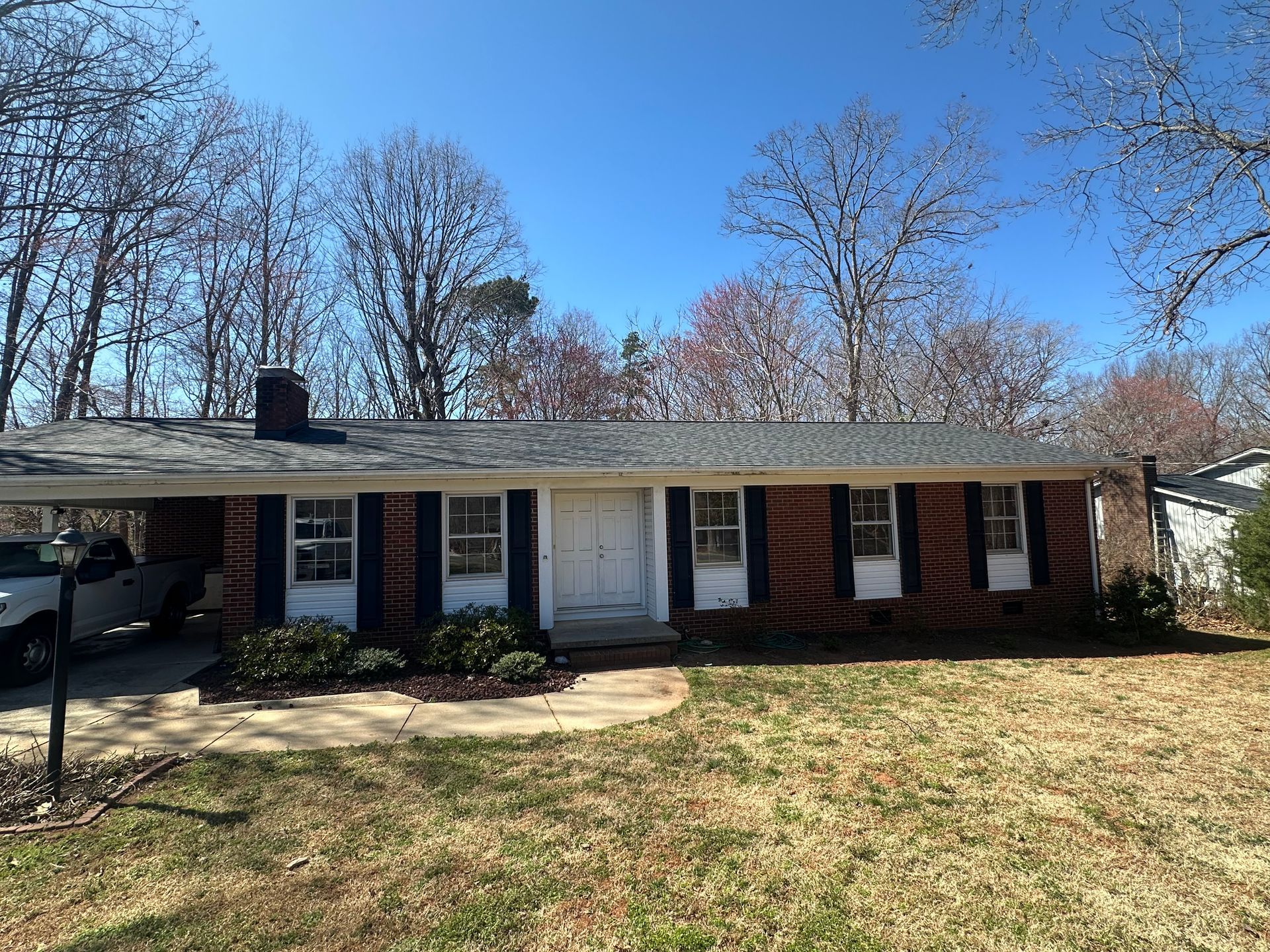 A brick house with a car parked in front of it.