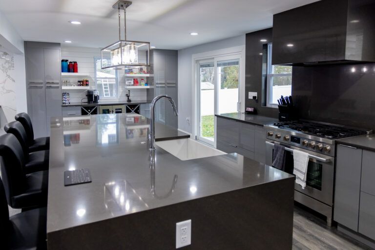 Modern kitchen with large island, stainless appliances, and sliding glass door to patio