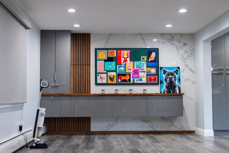 Modern lobby with a long desk, colorful wall art, and a black dog poster on marble walls.