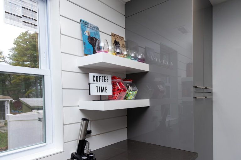 Small white shelf in a bright room with coffee decor, snacks, and a “COFFEE TIME” sign.