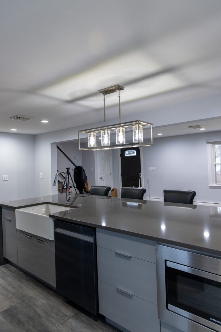Modern kitchen with large island, stainless appliances, and pendant lights