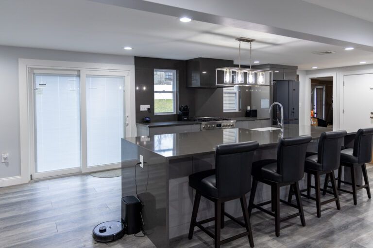 Modern kitchen and dining area with island, bar stools, and sliding glass doors