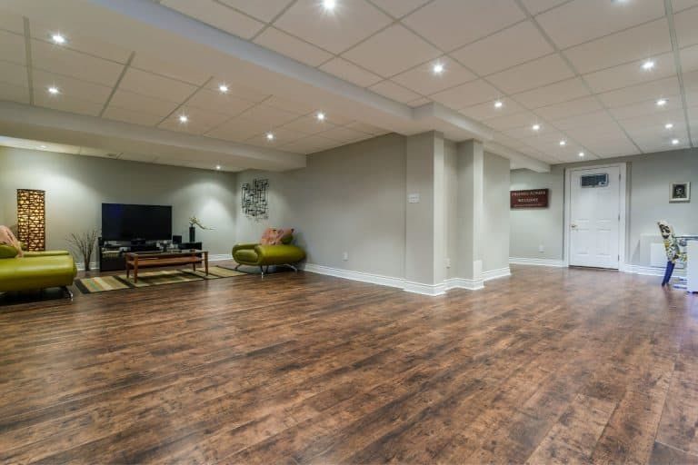 Empty indoor lounge with wood floors, recessed lighting, and seating along the walls