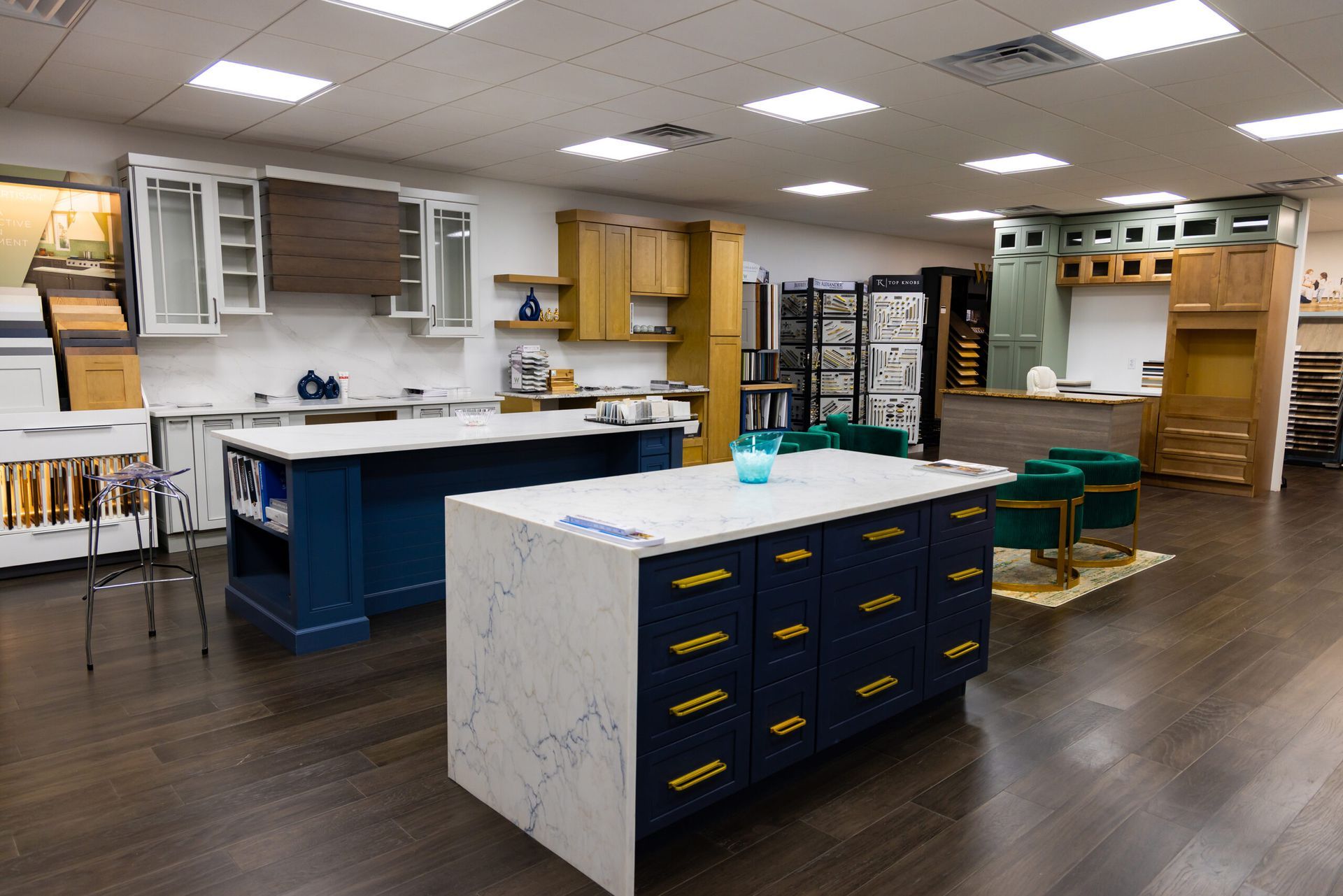 Empty modern kitchen showroom with blue island, white counters, and wood flooring
