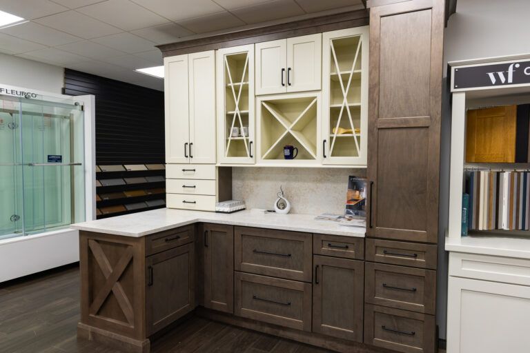 Kitchen display with two-tone cabinets, white countertops, and glass-front upper cupboards