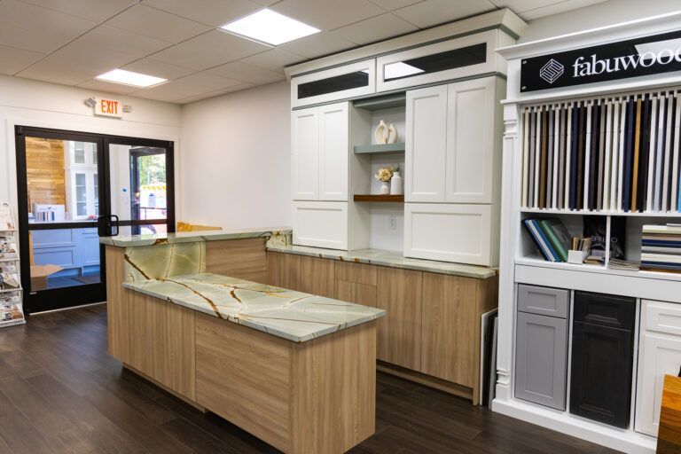 Interior of a flooring showroom with sample displays, white cabinets, and a central display counter.