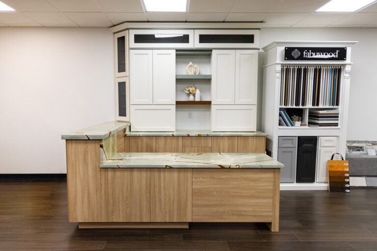 Kitchen display with white cabinets and light wood island in a showroom