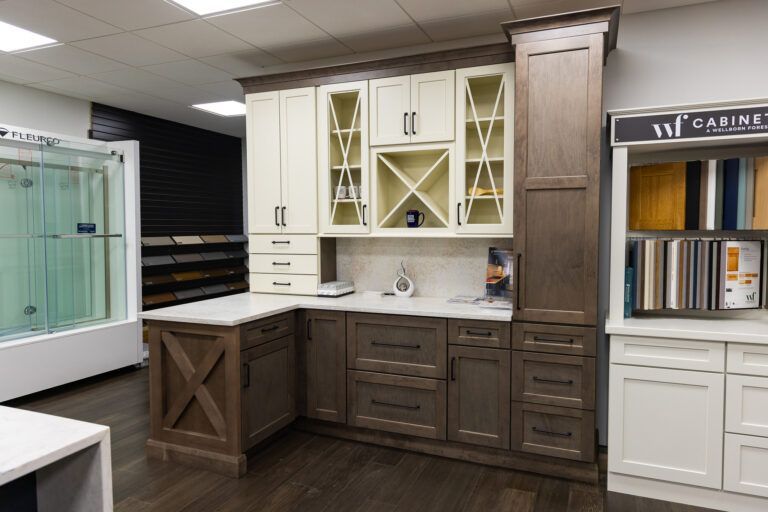 Display of white and brown kitchen cabinets with a countertop in a showroom