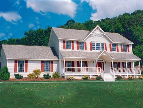 A large white house with red shutters and a large porch