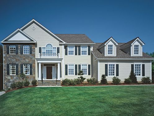 A large house with a lot of windows and shutters