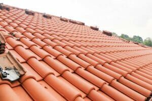 Red clay tile roof on a house, angled view.