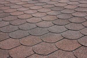 Close-up of a brown, scalloped shingle roof.