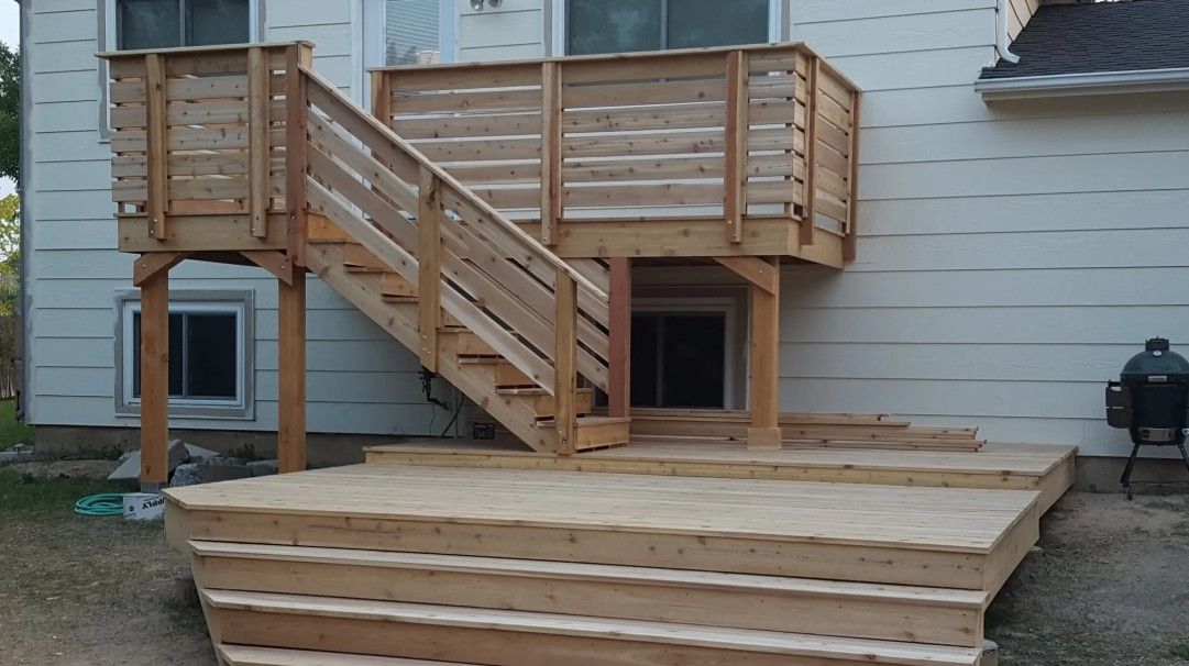Wooden backyard deck with stairs and railings attached to a house exterior