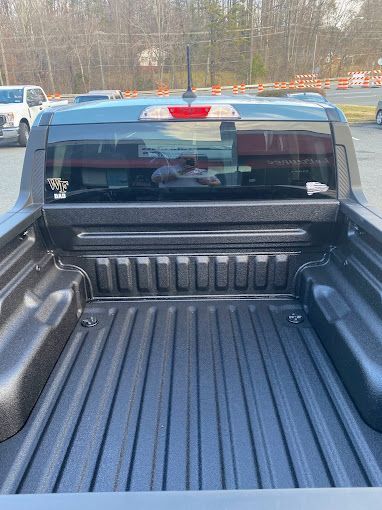The back of a truck is shown in a parking lot.