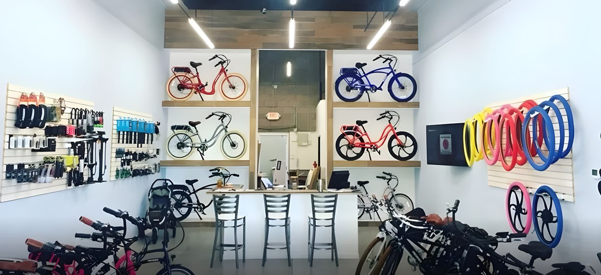 Bicycle shop interior with bikes, colorful wheels, and cycling gear displayed on the walls.