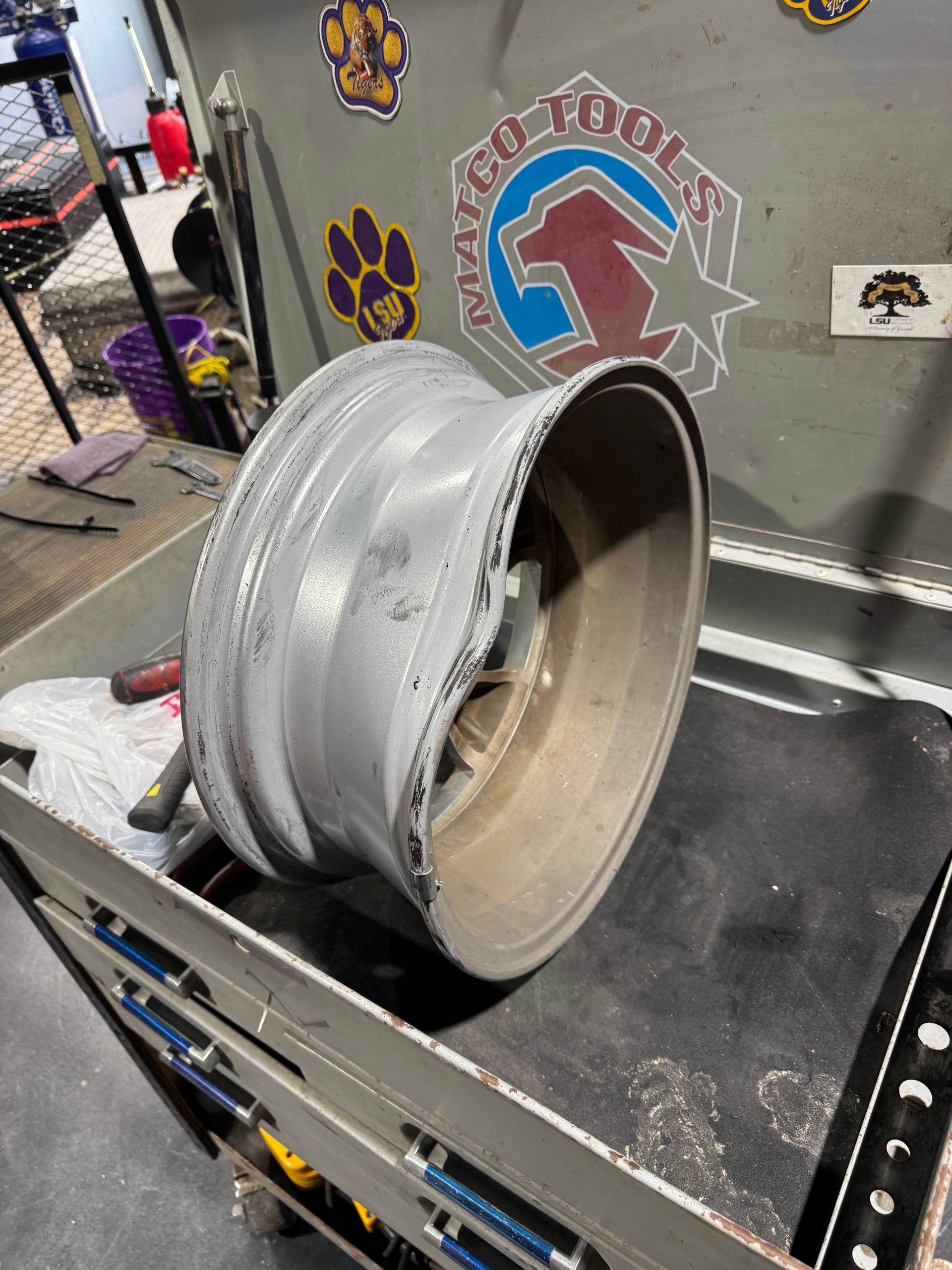 A wheel is sitting on a conveyor belt in a garage.