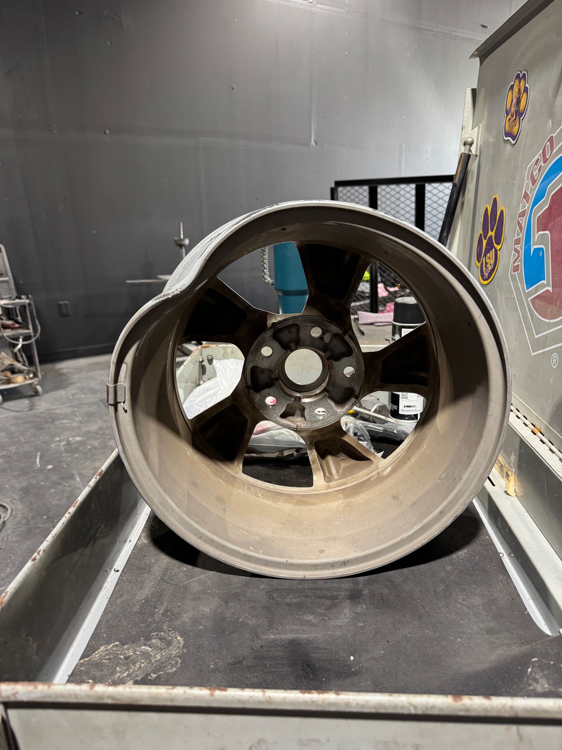 A broken wheel is sitting on top of a metal tray.