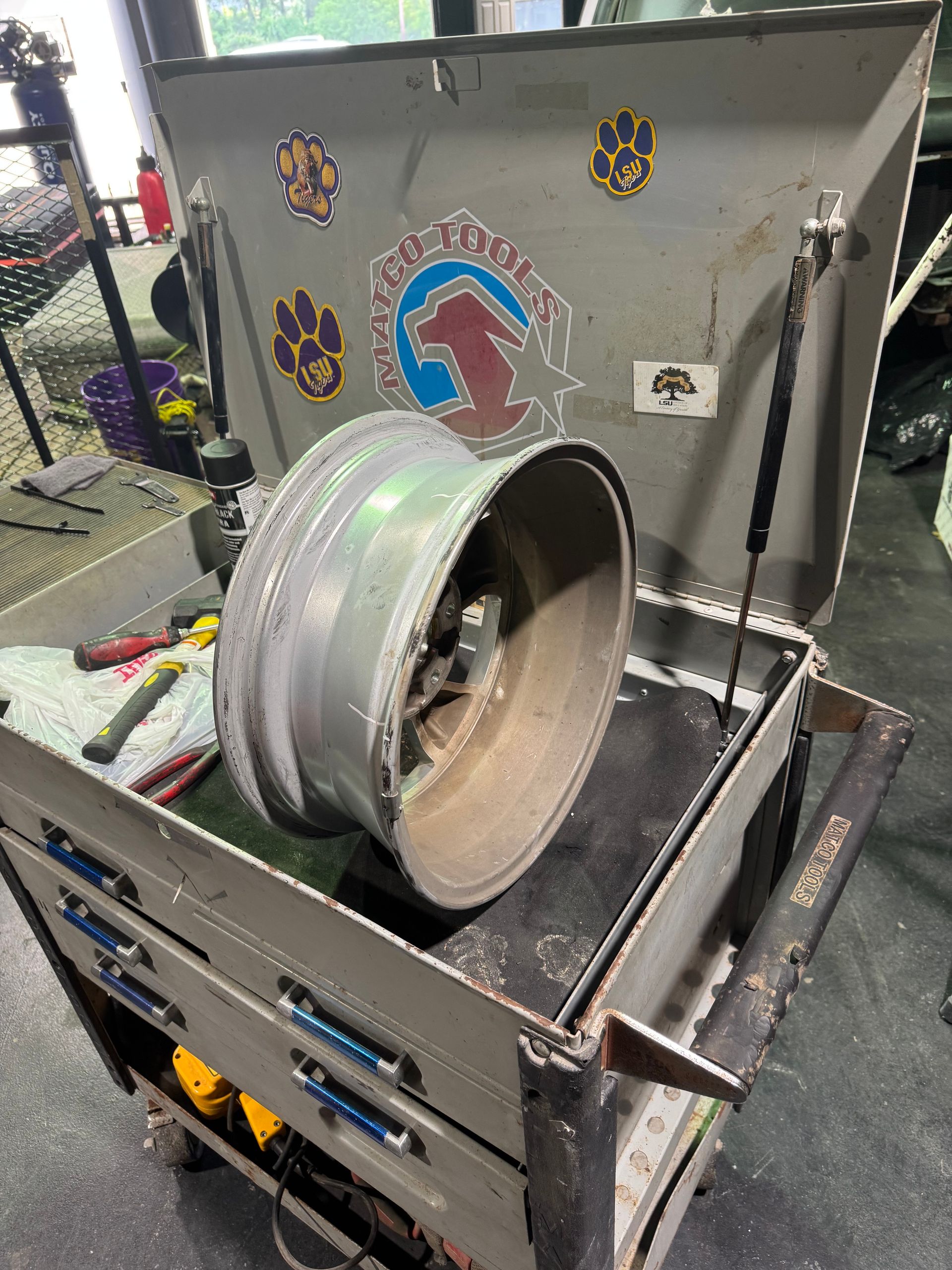 A wheel is sitting on top of a toolbox in a garage.