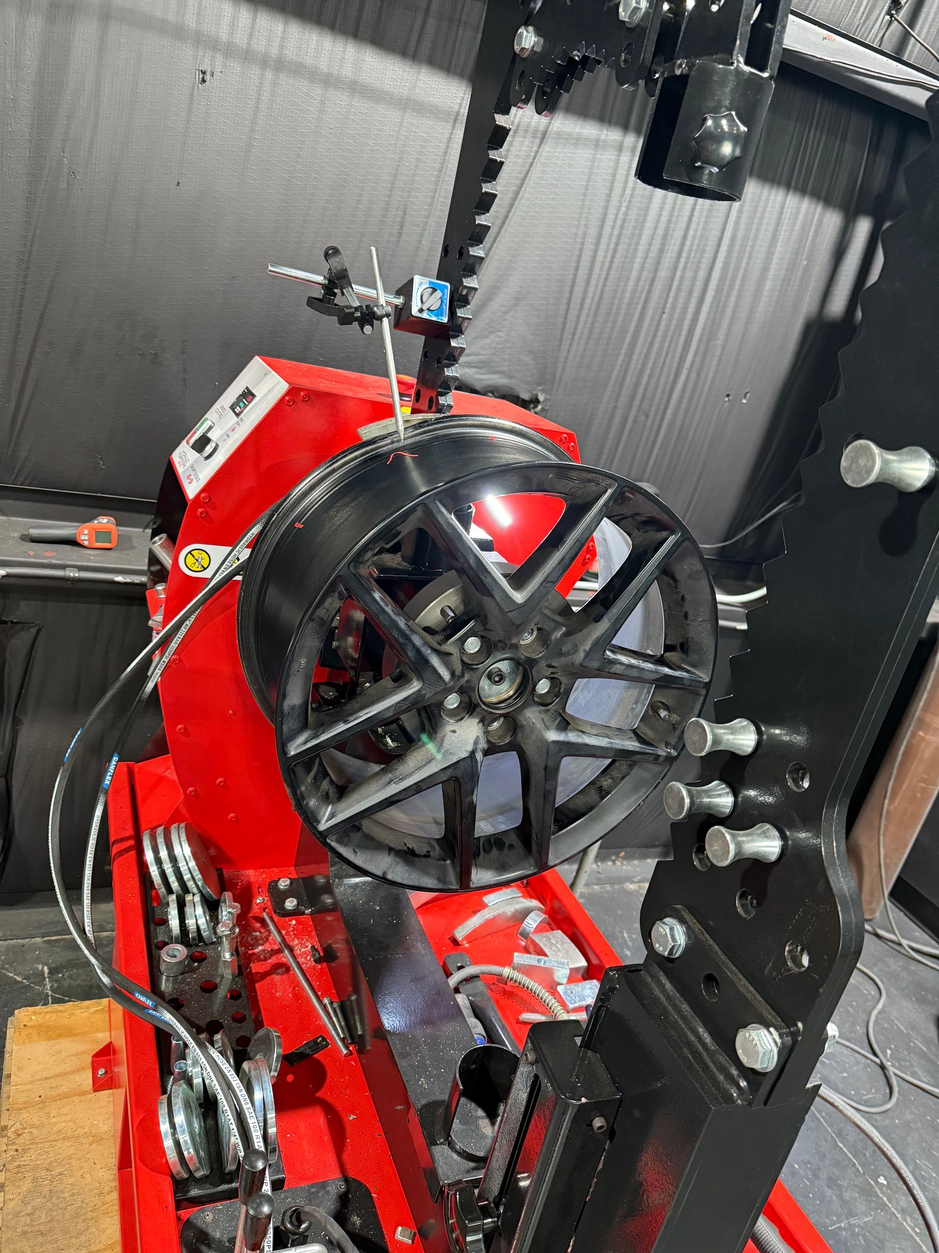 A machine is cutting a wheel in a garage.