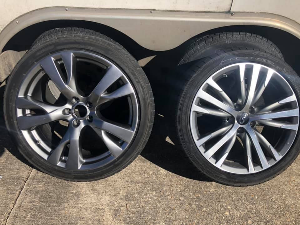 Two wheels are sitting next to each other on the side of a car.