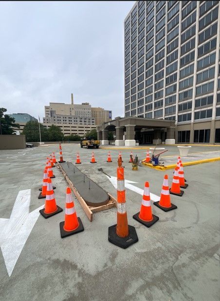 A bunch of orange and white traffic cones in a parking lot