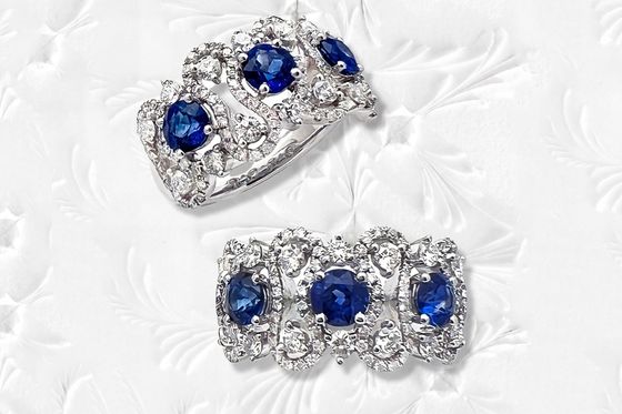 A pair of sapphire and diamond rings on a white surface