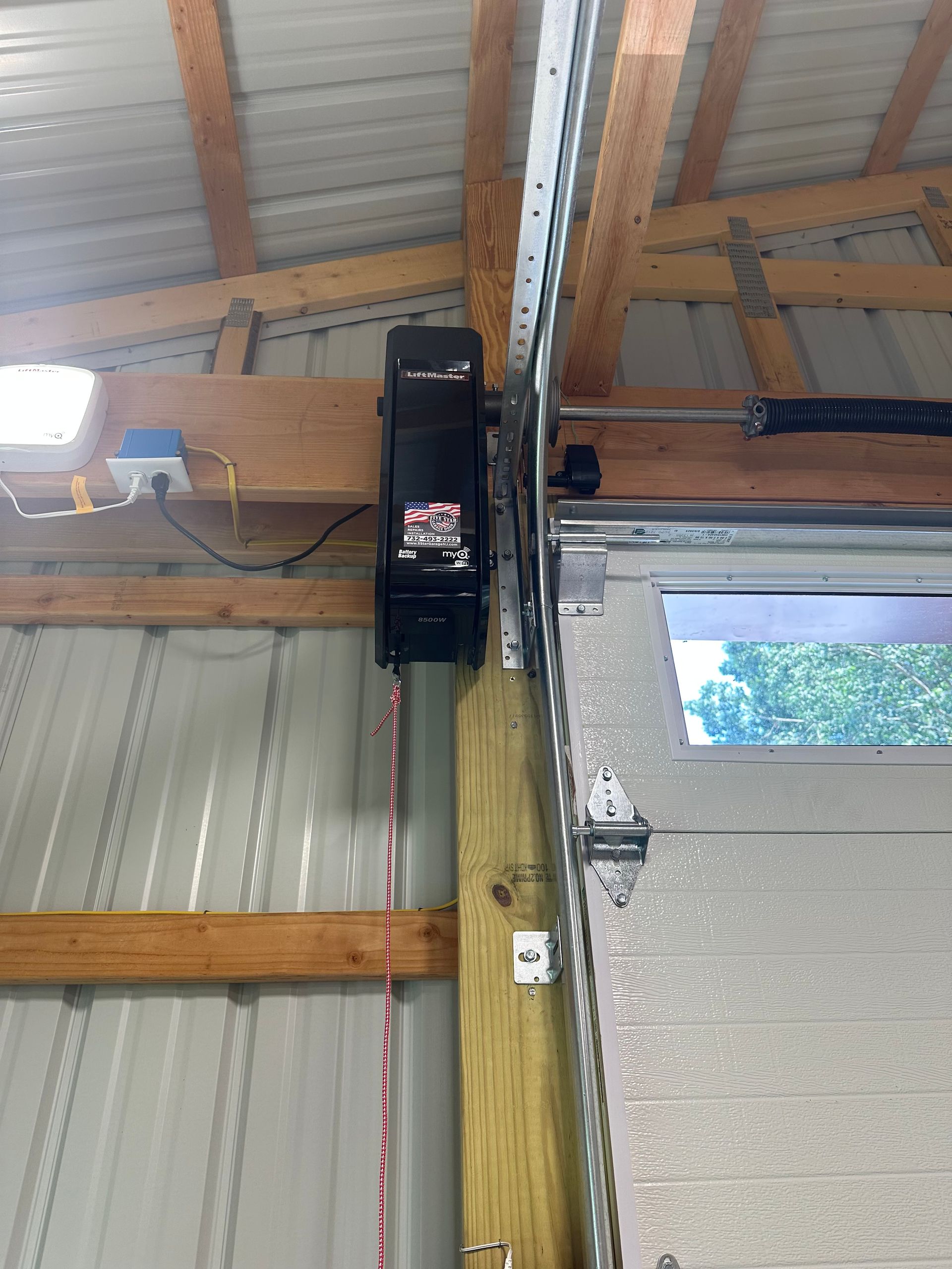 A garage door opener is mounted to the side of a garage door.