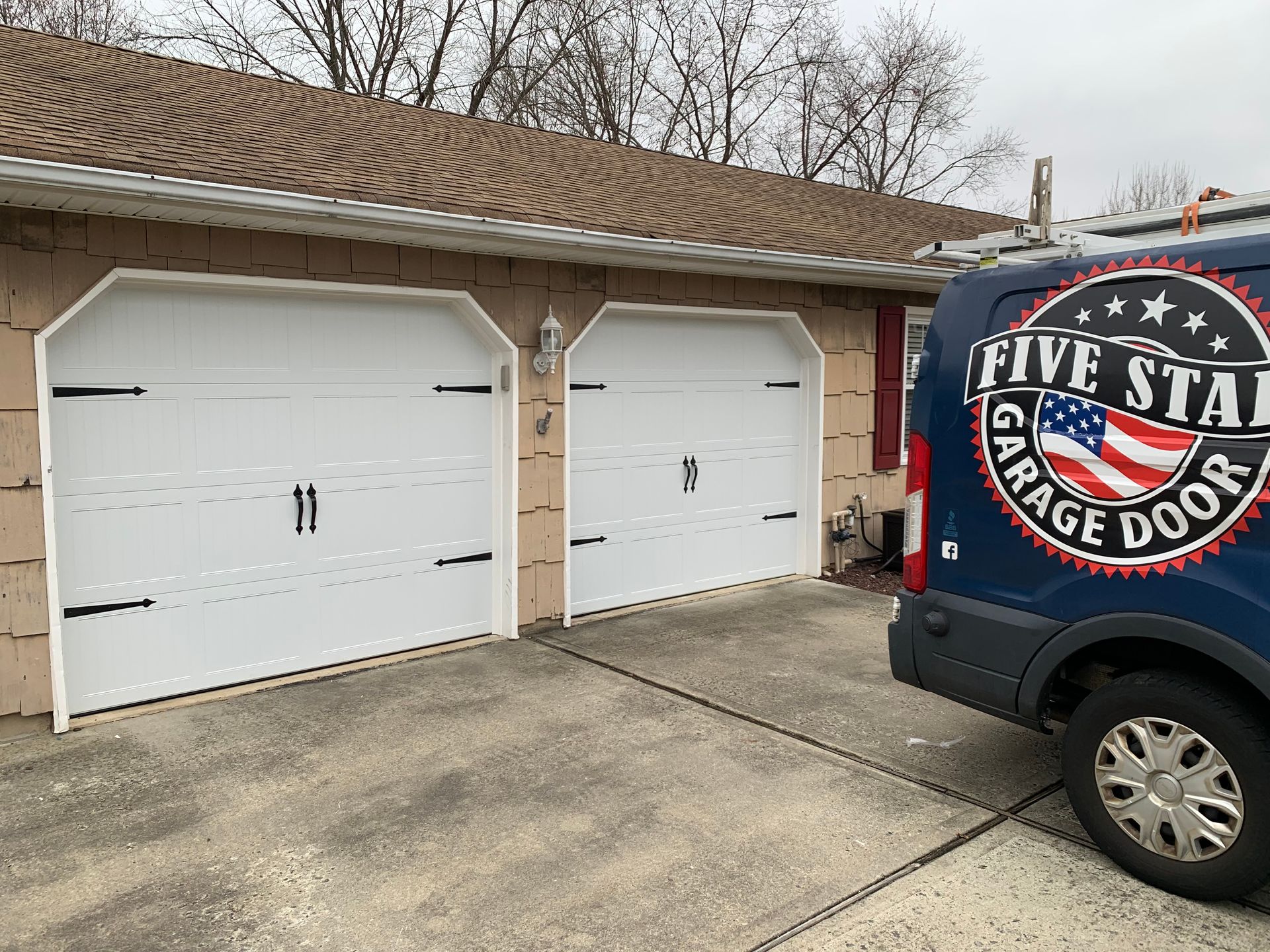A five star garage door van is parked in front of a house.