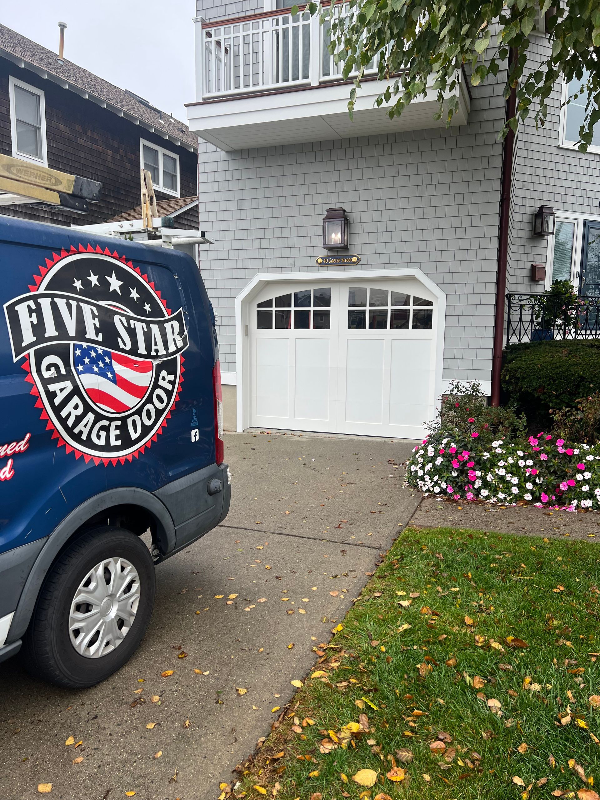 A five star garage door van is parked in front of a house.