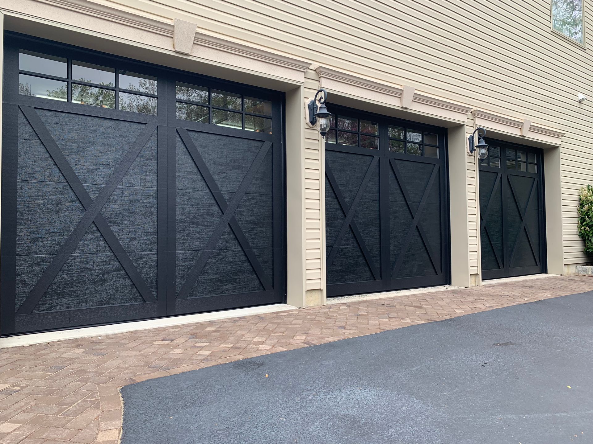 A row of black garage doors on a brick building