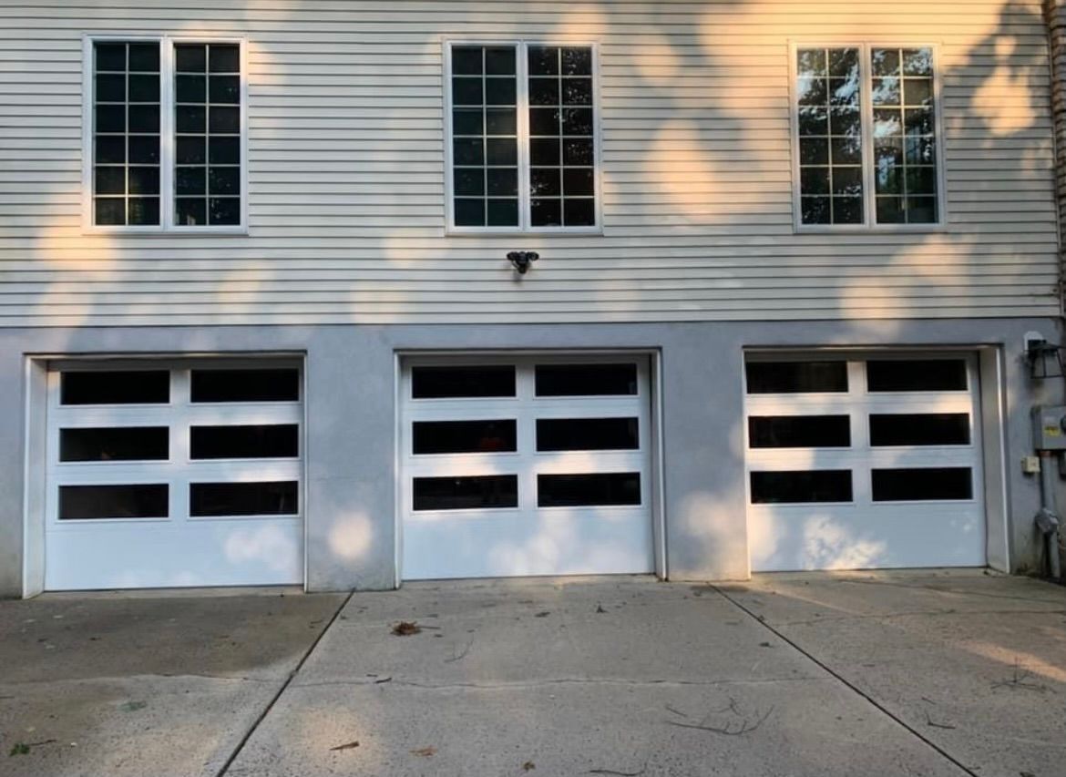 A white house with three garage doors and windows