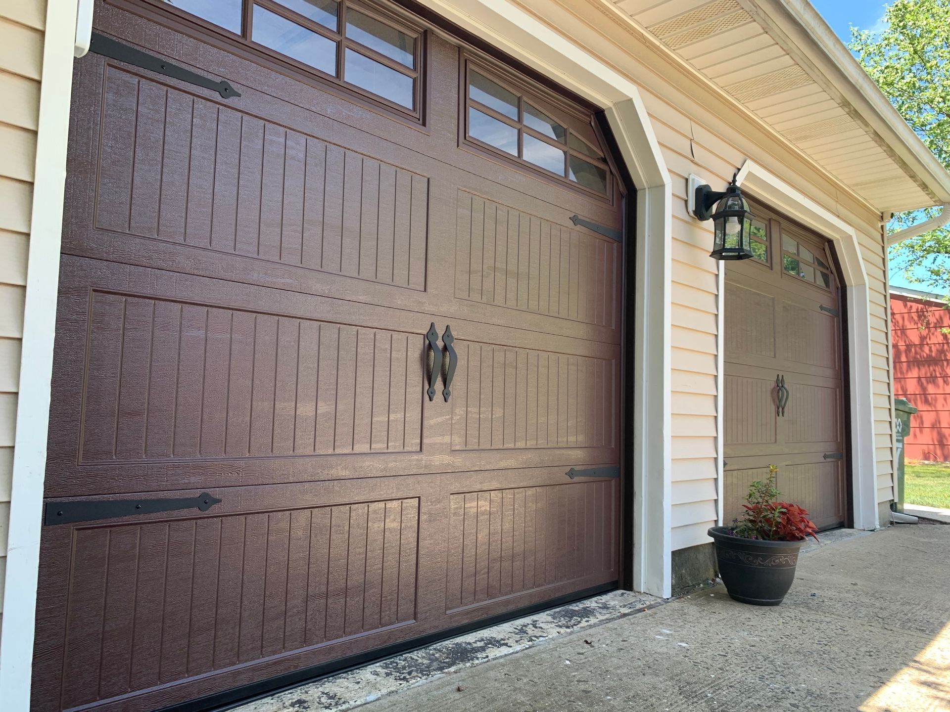 A large brown garage door is sitting on the side of a house.