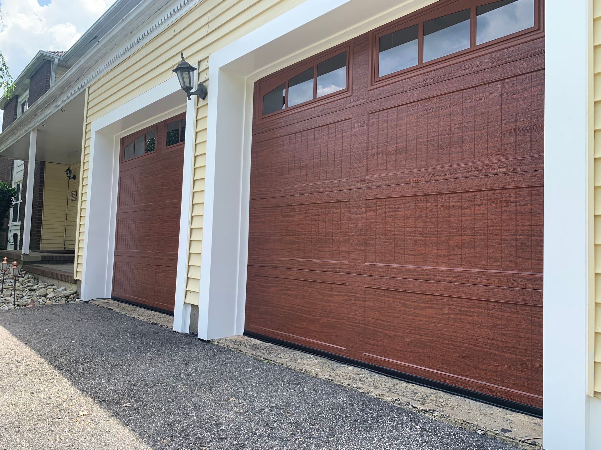 There are three garage doors on the side of a house.