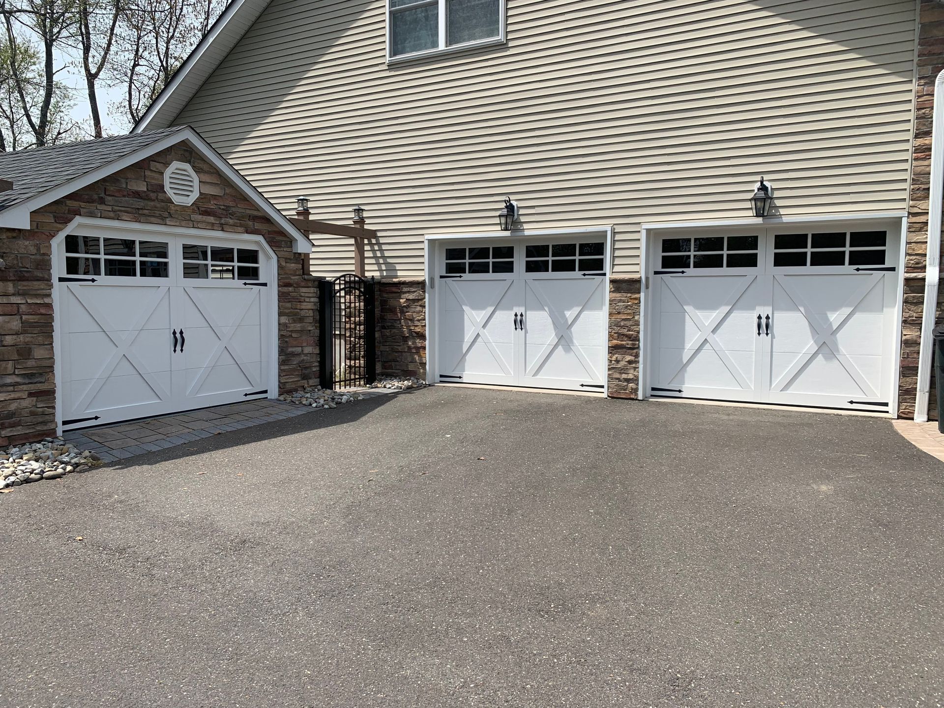There are three garage doors in front of a house.