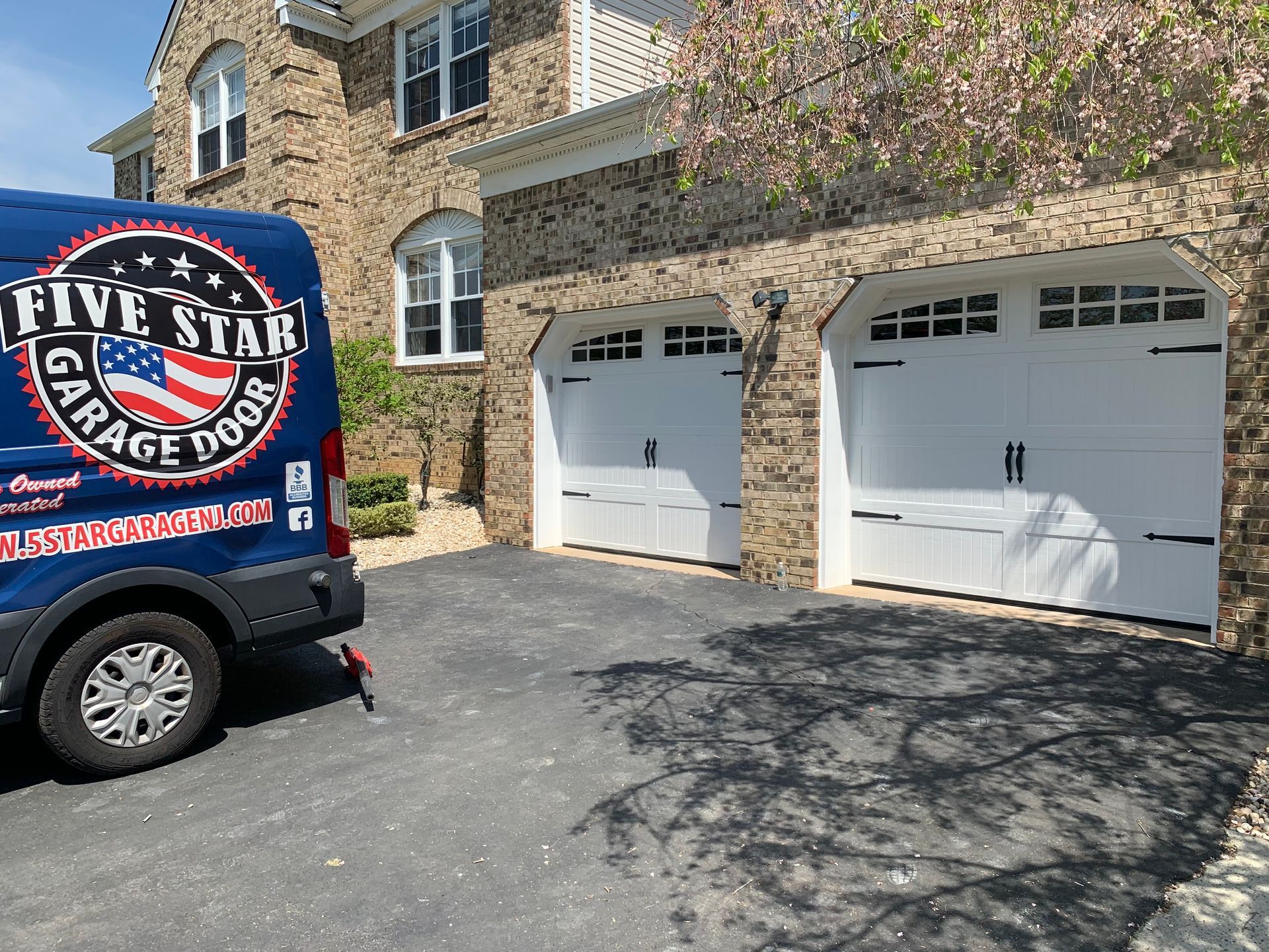 A five star garage door van is parked in front of a house.