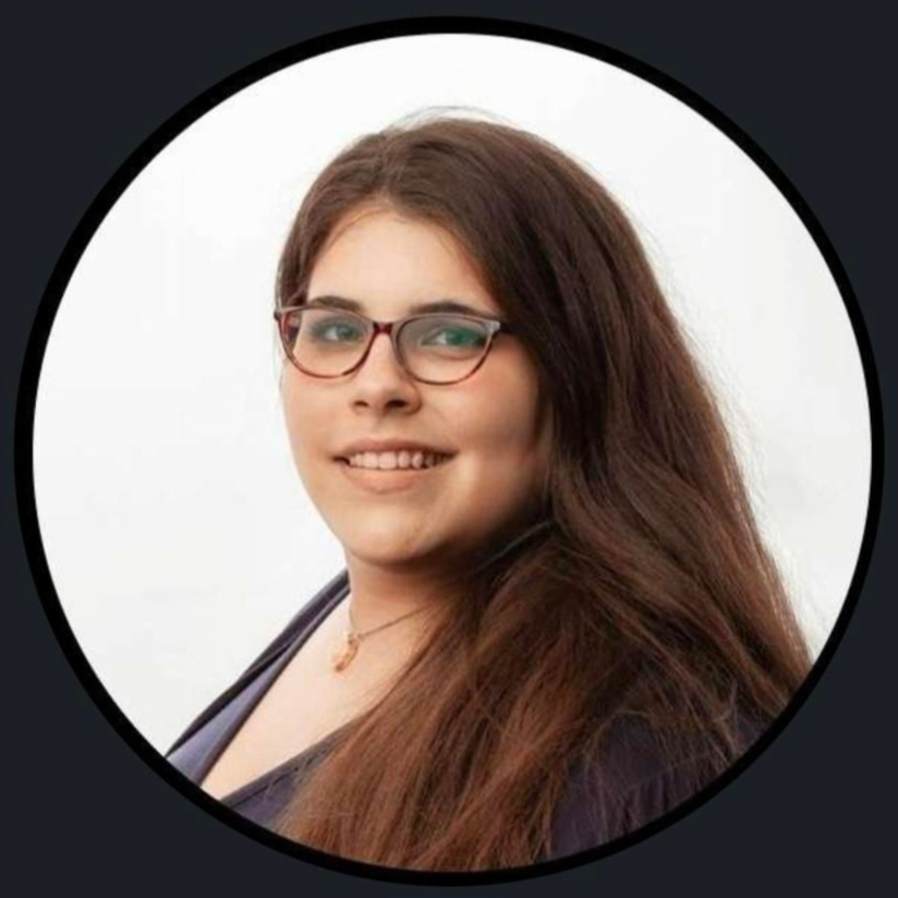 Portrait of a smiling person with glasses and long brown hair on a light background