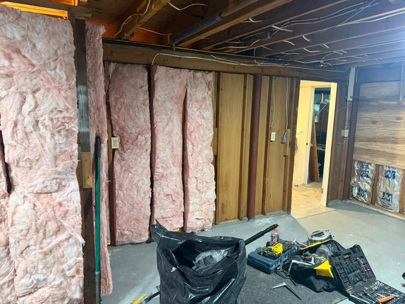 Basement renovation with pink insulation batts installed between wood studs