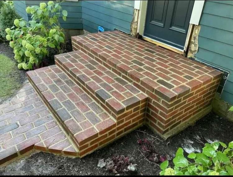 Brick steps leading to a teal house entrance