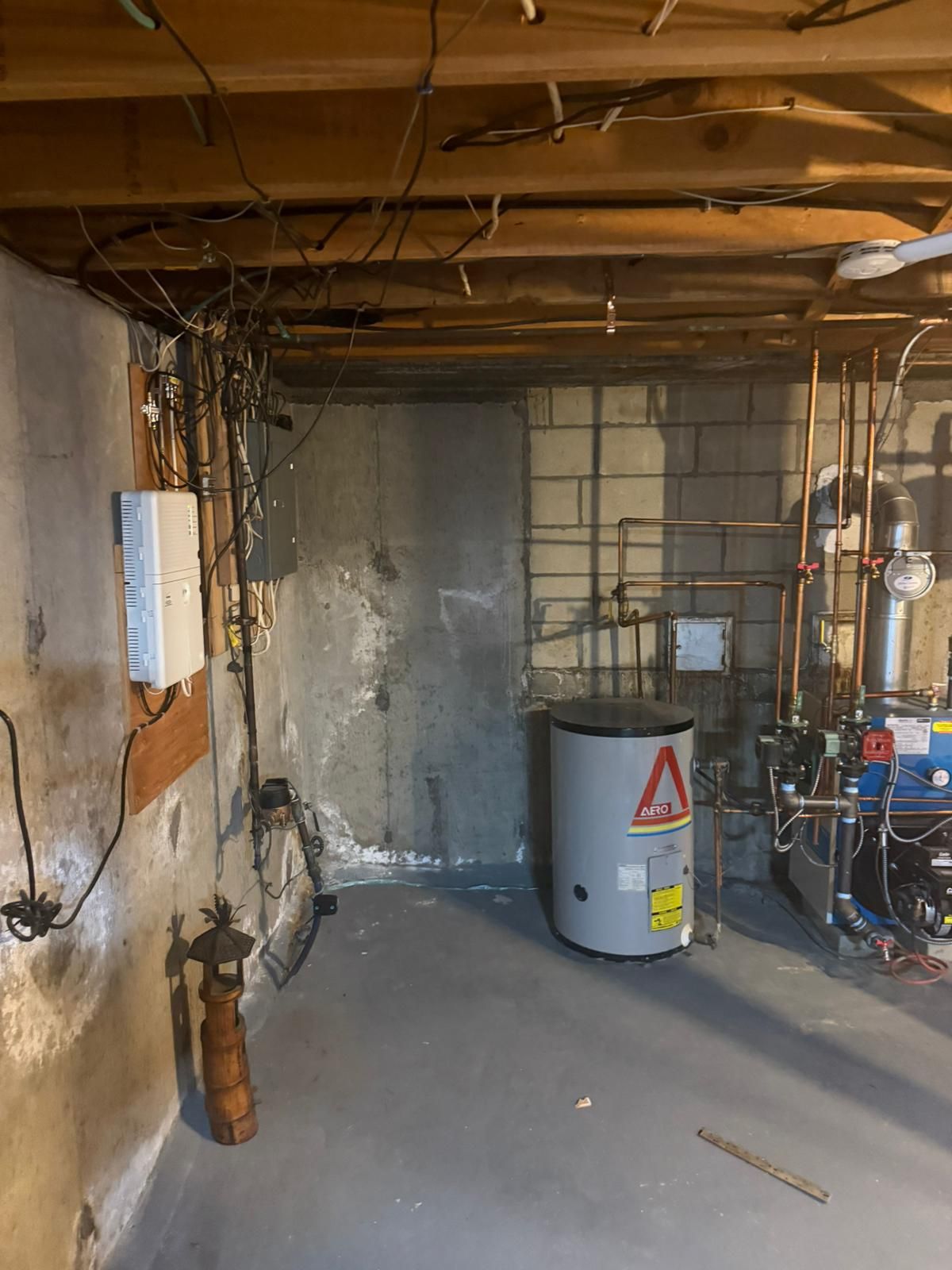 Basement with concrete walls, water heater, pipes, and electrical wiring
