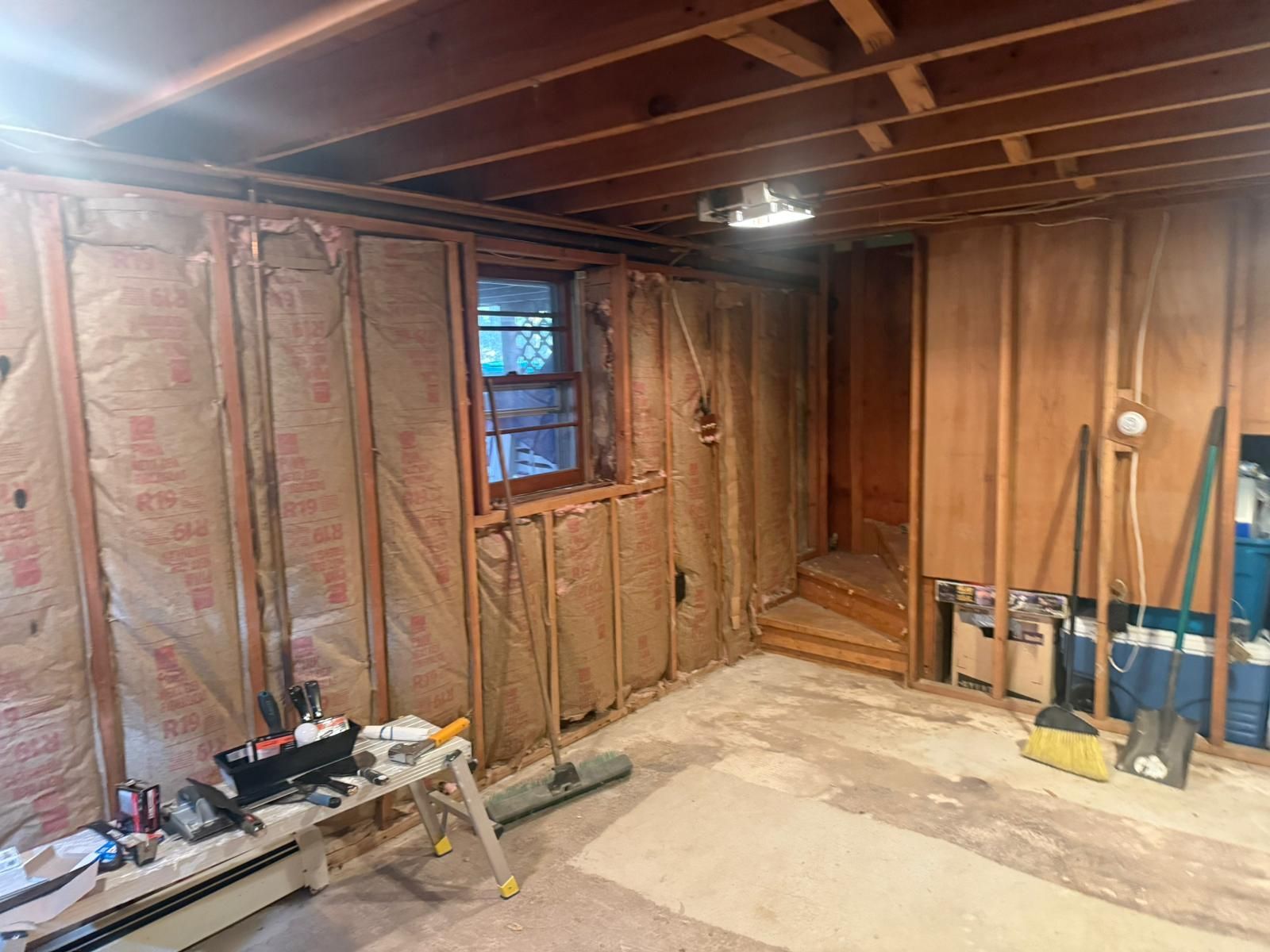 Walls with insulation, window, tools, and exposed studs