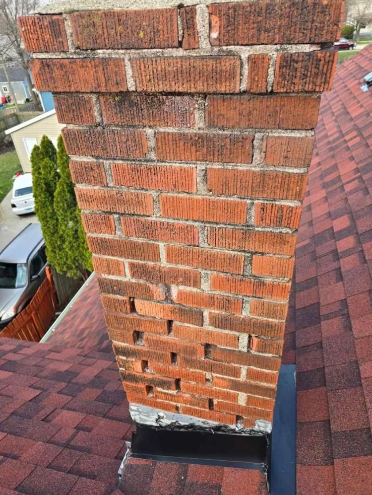 Brick chimney on a red shingled roof
