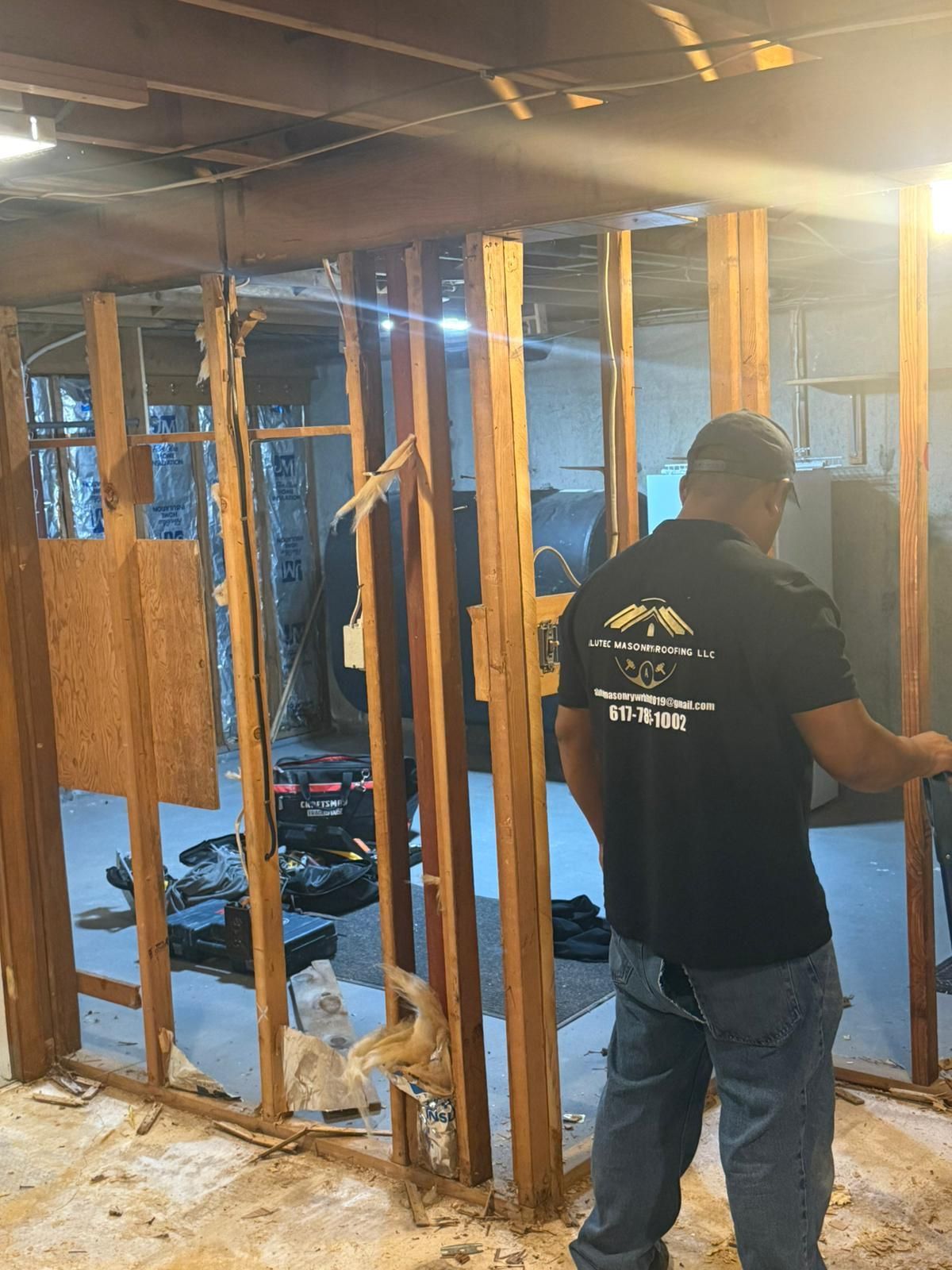 Man inspecting interior wall demolition in a basement