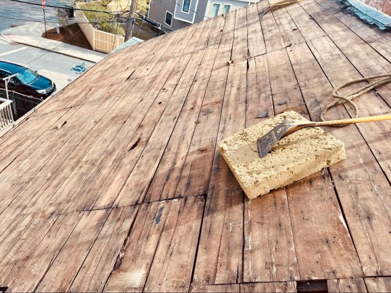 Wooden rooftop with a cleaning tool resting on it, possibly for roof repair.