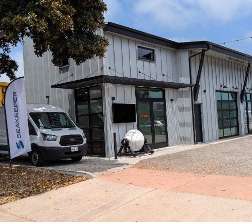 A white van is parked in front of a large building