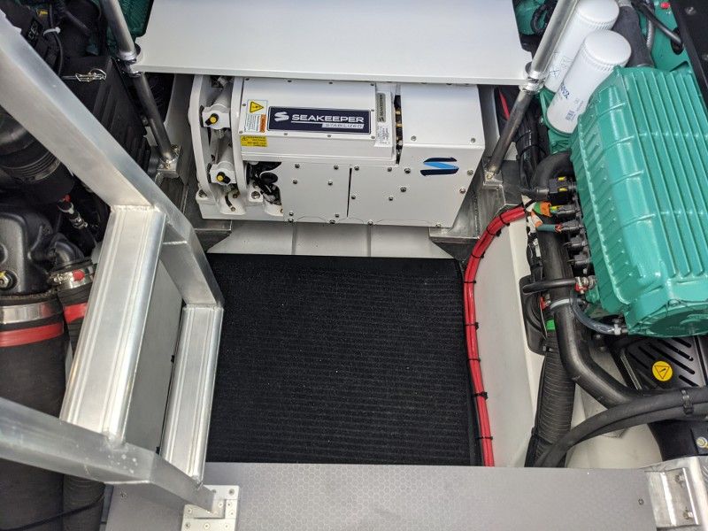 The inside of a boat with a green engine and a white battery