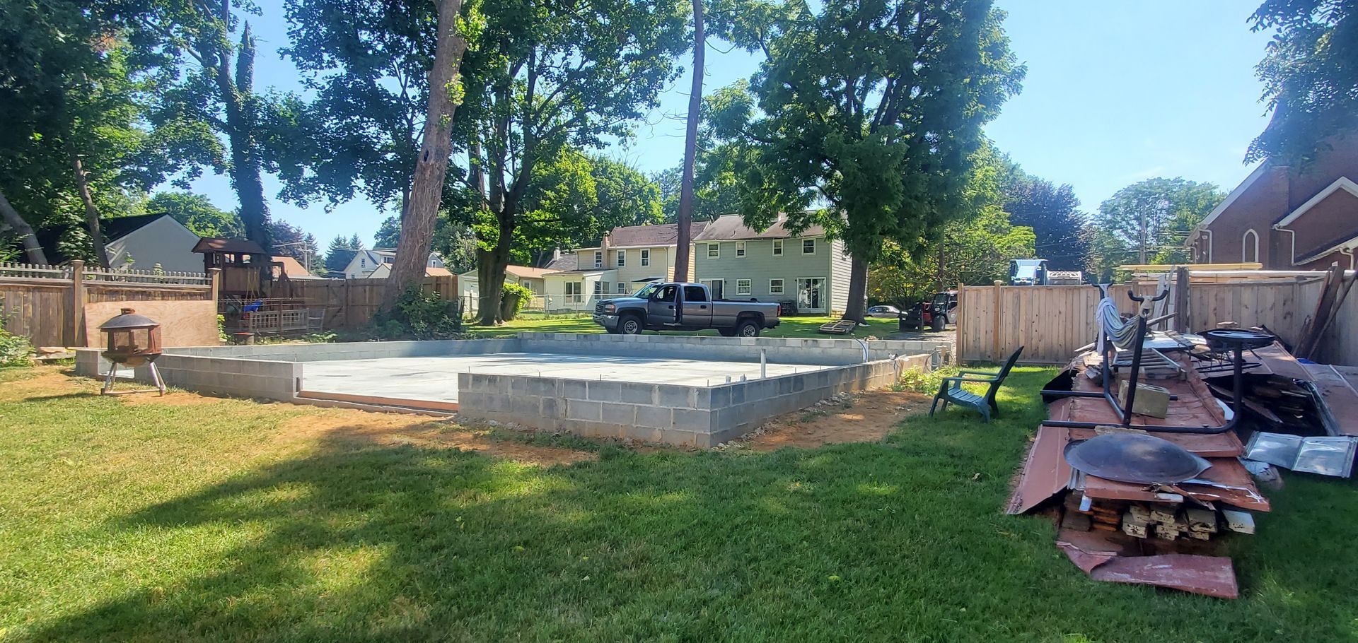 A truck is parked in the backyard of a house.