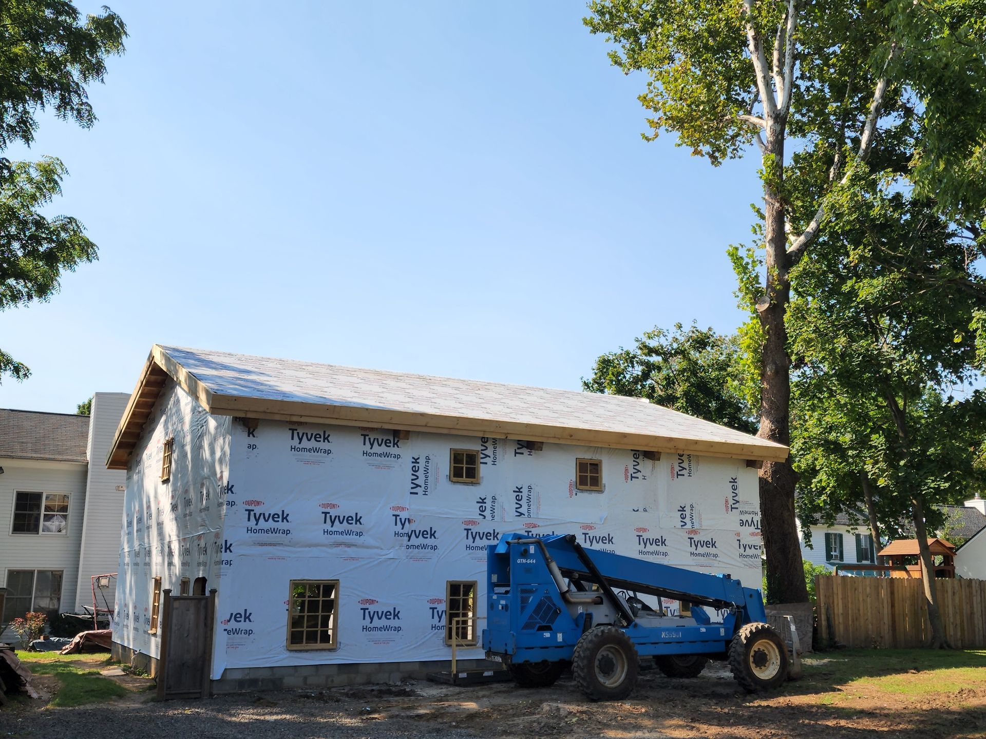 A blue truck is parked in front of a building under construction.