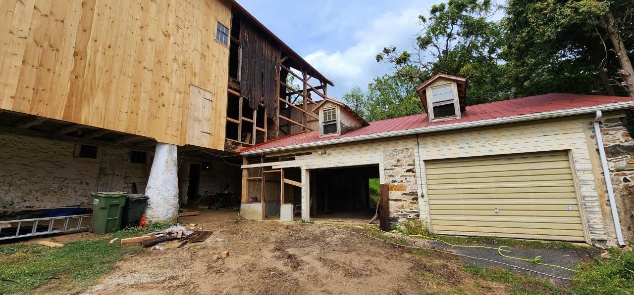 An old barn before with a garage underneath it is being demolished.