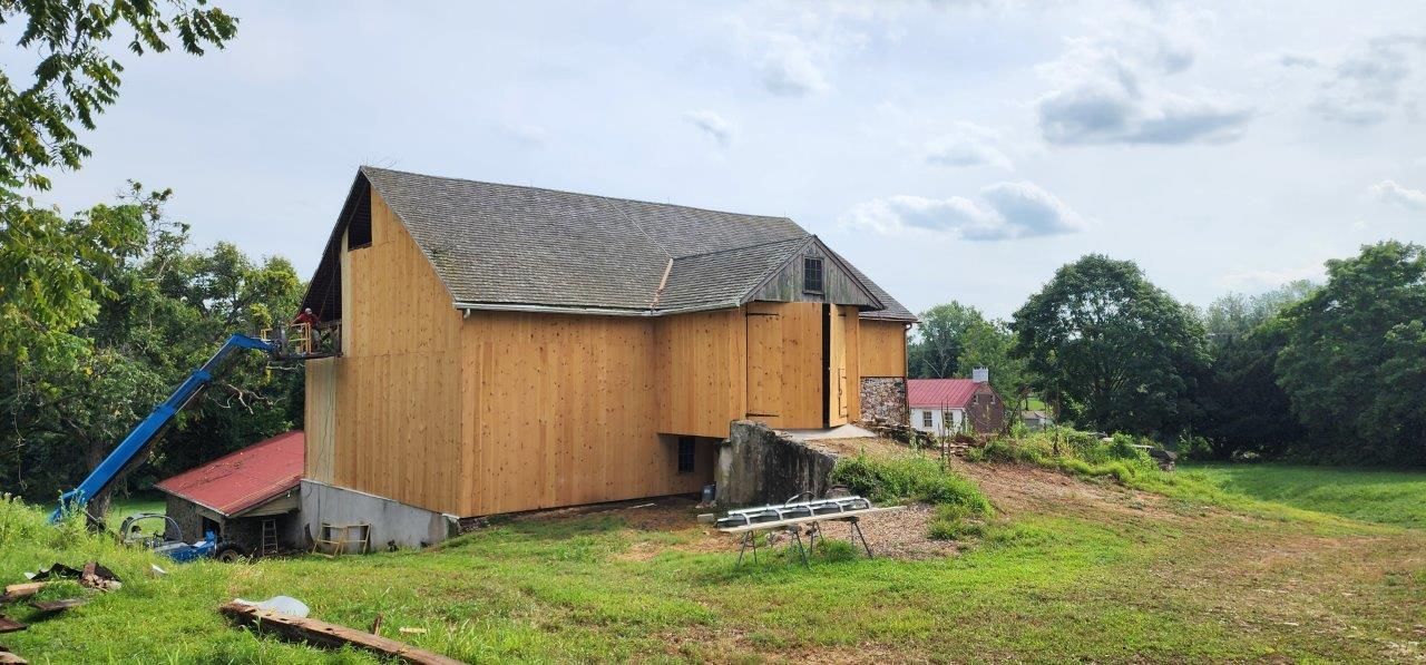 A restored barn in a grassy field.