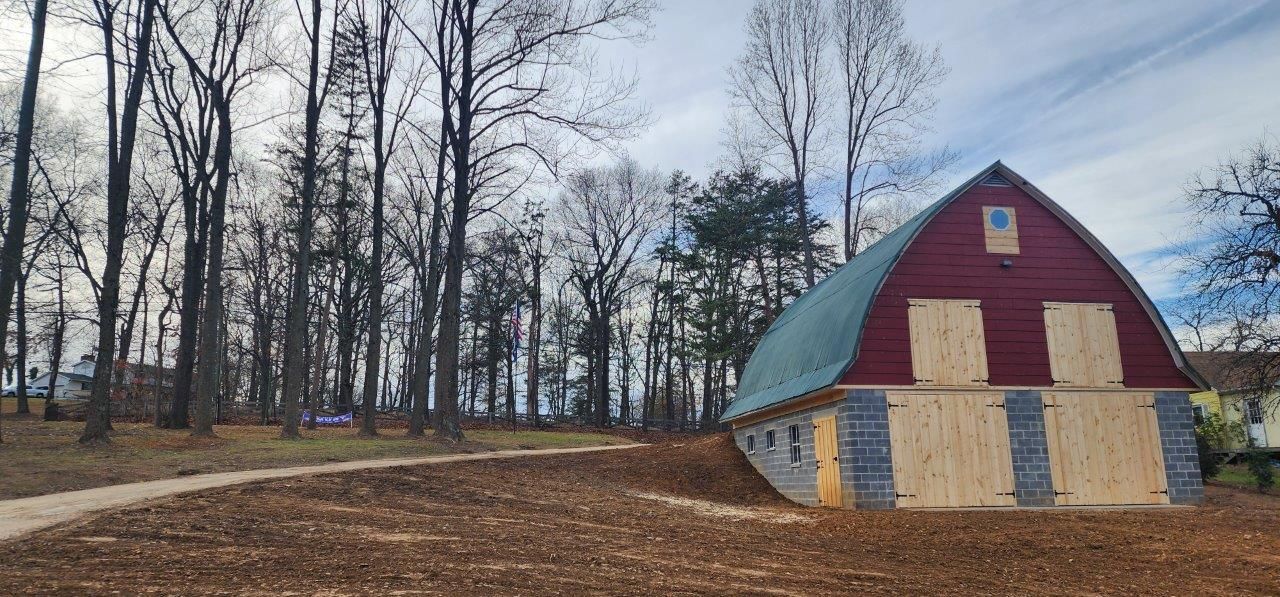 A restored barn with a green roof.